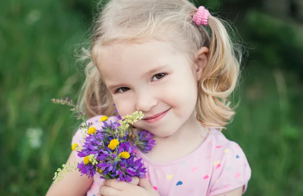 Cute little girl holding a bouquet — Stock Photo, Image