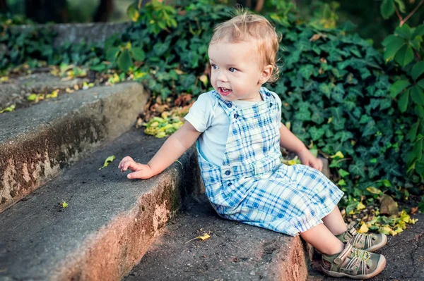 Ładny toddler chłopiec siedzący na schodach — Zdjęcie stockowe