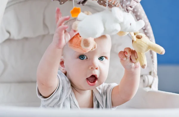 Bebek beşiğinde oynarken oturuyor 