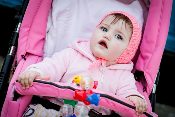 Surprised baby girl in stroller — Stock Photo, Image