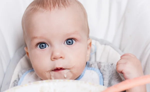 Söt baby äter gröt — Stockfoto