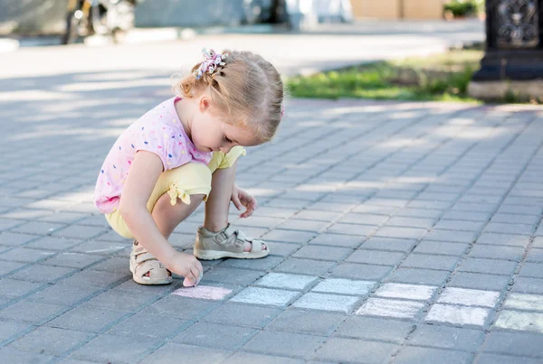 Schattig klein meisje tekenen met krijt — Stockfoto