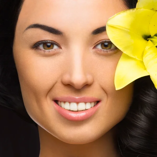kıvırcık siyah saçları ve beyaz zemin üzerine temiz cilt ile sevimli gülümseyen kız muhteşem sarı çiçek portresi ile güzel bir kadın