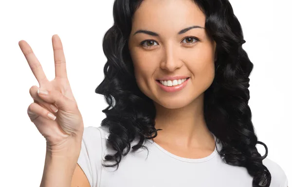 barış işareti gösterilen kıvırcık siyah saçlı genç ve güzel bir kadın portresi