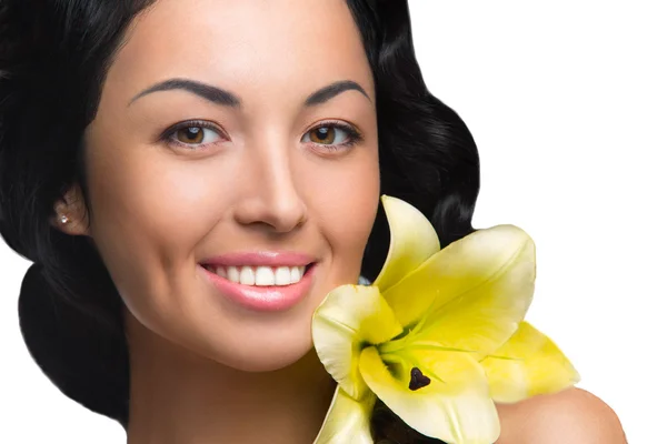 Beautiful woman with amazing yellow flower portrait of charming smiling girl with long curly black hair and clean skin on white background — Stock Photo, Image