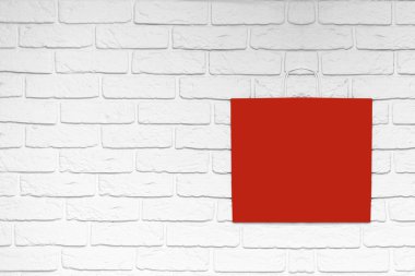 Hediye paketleri. Çevrimiçi ve çevrimdışı alışveriş. Beyaz tuğlalı arka planda kırmızı paket.