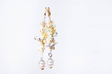 Kadınların mücevherleri: beyaz arka planda izole edilmiş çok renkli taşlı küpeler.