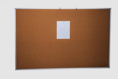 A4 beyaz çarşaf kahverengi bir mantar panoya tutturulmuş. Beyaz bir duvarda bir tahta asılı. Ofis ve planlama kavramı.