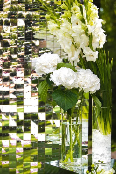 Jarrón blanco con flores en un restaurante, mesa servida. Cesta con flores, kibana, floristería de la boda. — Foto de Stock
