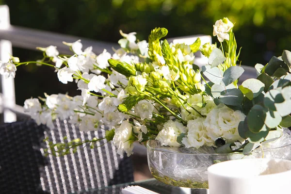 Vaso branco com flores em um restaurante, mesa servida. Cesta com flores, kibana, floricultura de casamento. — Fotografia de Stock