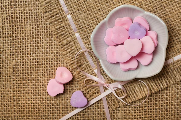 Heart-shaped sweets on sack tablecloth — Stock Photo, Image