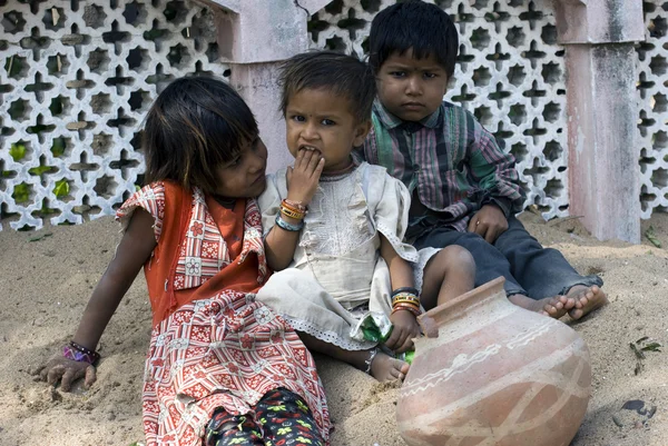 Üç yoksul gecekondu çocuk kum üzerinde oyun - Stok İmaj