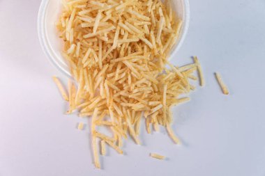 Beyaz arka planda patates kamışı olan beyaz kase.