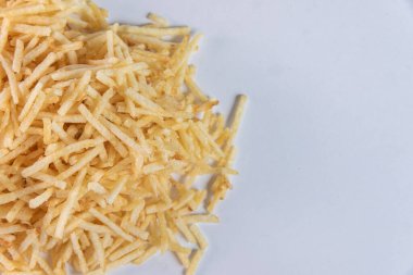 Beyaz arka planda patates kamışı olan beyaz kase.