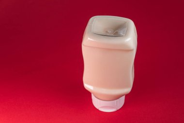 Kırmızı arkaplanda mayonez kutusu