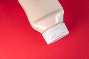 Kırmızı arkaplanda mayonez kutusu