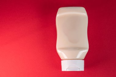 Kırmızı arkaplanda mayonez kutusu