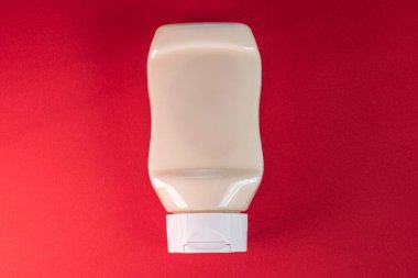 Kırmızı arkaplanda mayonez kutusu