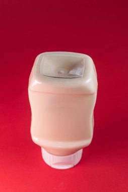 Kırmızı arkaplanda mayonez kutusu