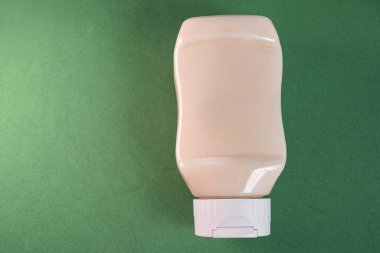 Yeşil arkaplanda mayonez kutusu