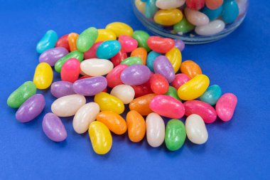 Cam kapta mavi arka planda birkaç tane jelibon var.