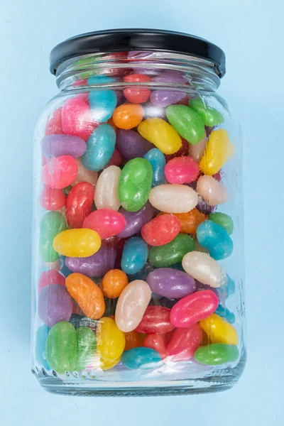 Several Jelly Beans Blue Background Glass Pot — Stock Photo, Image