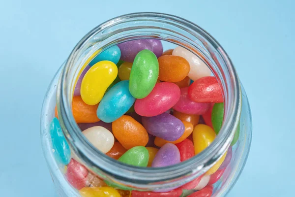 Several Jelly Beans Blue Background Glass Pot — Stock Photo, Image