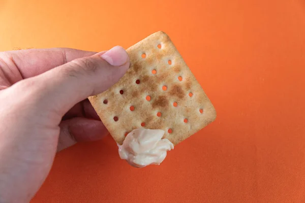 Galleta Sal Con Mayonesa Fondo Naranja Hombre Sosteniendo — Foto de Stock