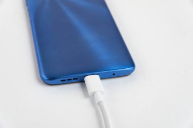 Mavi cep telefonu USB kablo tipi C 'ye bağlanıyor - şarj ediliyor