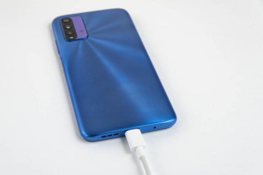 Mavi cep telefonu USB kablo tipi C 'ye bağlanıyor - şarj ediliyor