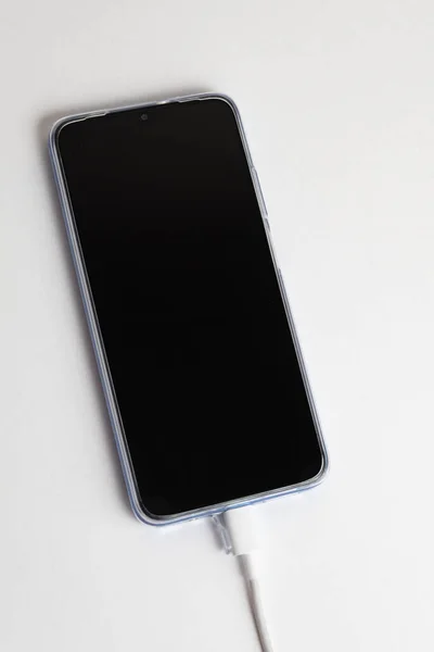 UsbケーブルタイプCに接続された青色の携帯電話 — ストック写真
