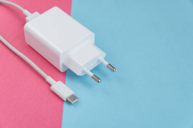 Şarj aleti ve USB kablo tipi C pembe ve mavi arkaplan üzerinde