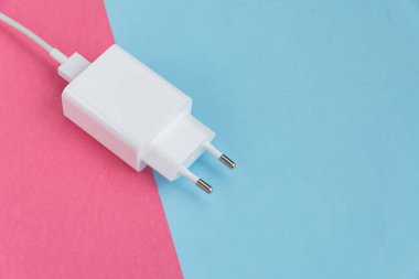 Şarj aleti ve USB kablo tipi C pembe ve mavi arkaplan üzerinde