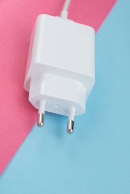 Şarj aleti ve USB kablo tipi C pembe ve mavi arkaplan üzerinde