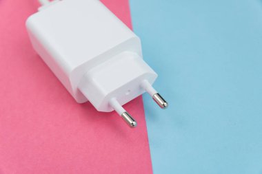 Şarj aleti ve USB kablo tipi C pembe ve mavi arkaplan üzerinde