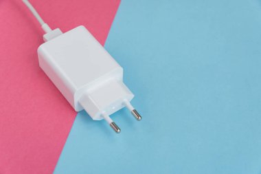 Şarj aleti ve USB kablo tipi C pembe ve mavi arkaplan üzerinde