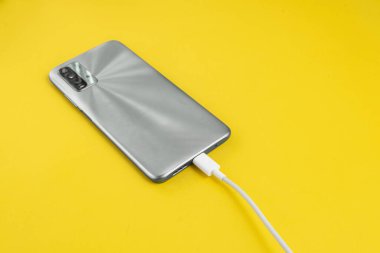 Gri cep telefonu USB kablo tipi C 'ye bağlanıyor - şarj ediliyor