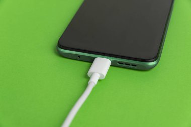 USB kablo tipi C 'ye bağlı yeşil cep telefonu - şarj ediliyor