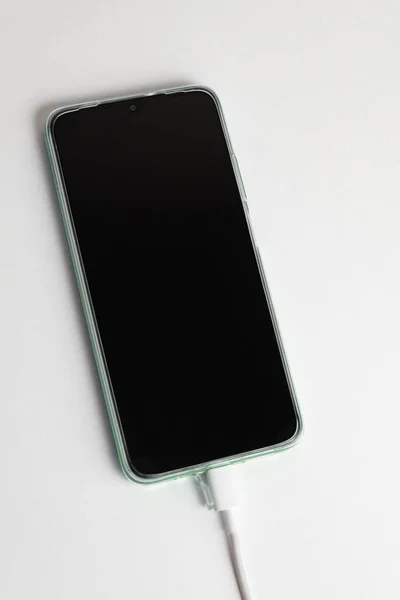 UsbケーブルタイプCに接続された緑の携帯電話 — ストック写真