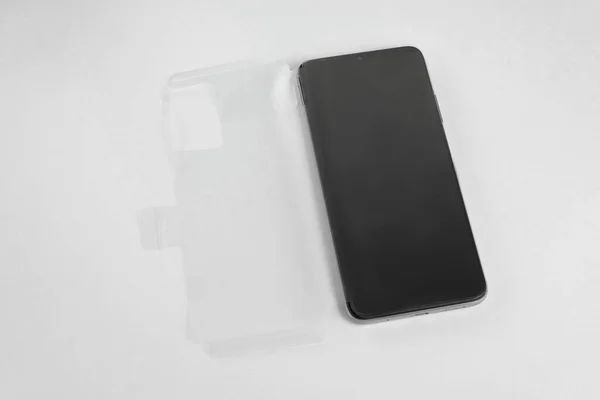 Nuevo Teléfono Móvil Con Cubierta Transparente Sobre Fondo Blanco Aislado — Foto de Stock