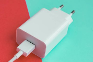 Şarj aleti ve USB kablo tipi C pembe ve mavi arkaplan üzerinde