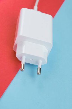 Şarj aleti ve USB kablo tipi C pembe ve mavi arkaplan üzerinde