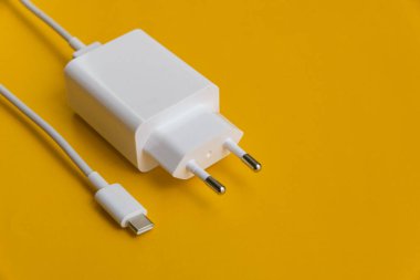 Şarj aleti ve USB kablo tipi C turuncu arkaplan üzerinde