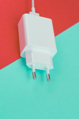 Şarj aleti ve USB kablo tipi C pembe ve mavi arkaplan üzerinde