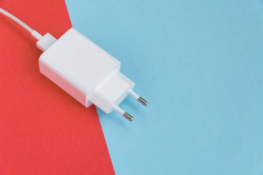 Şarj aleti ve USB kablo tipi C pembe ve mavi arkaplan üzerinde