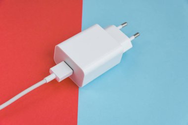 Şarj aleti ve USB kablo tipi C pembe ve mavi arkaplan üzerinde