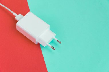 Şarj aleti ve USB kablo tipi C pembe ve mavi arkaplan üzerinde
