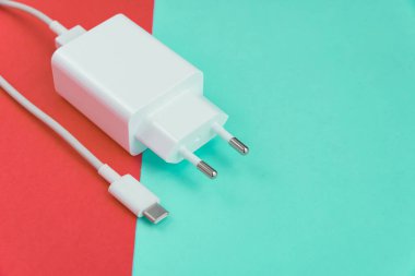 Şarj aleti ve USB kablo tipi C pembe ve mavi arkaplan üzerinde