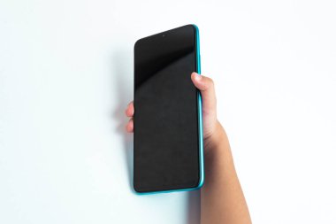 Cep telefonunu beyaz arkaplan üzerinde tutan çocuk
