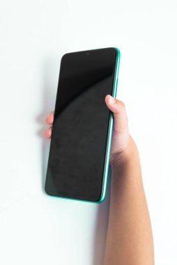 Cep telefonunu beyaz arkaplan üzerinde tutan çocuk